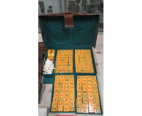 A vintage Mahjong set in leather case with four counter trays and table matt 