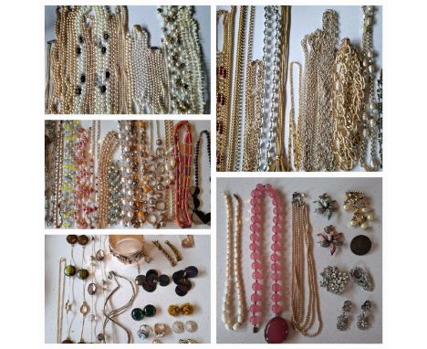 A quantity of costume jewellery housed in a red basket to include a Chinese pink glass bead necklace with white metal clasp, 