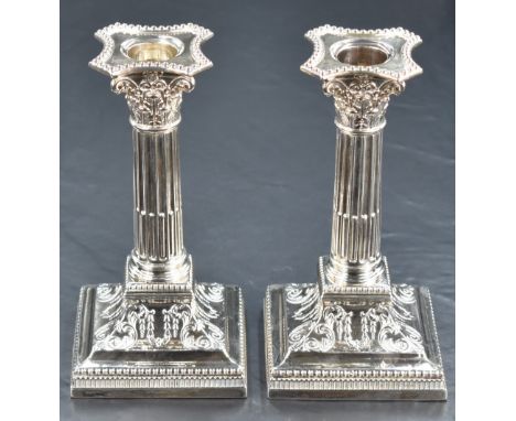 A pair of Victorian silver candlesticks of column design, having concave square detachable sconces with bead trim, embossed d