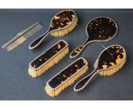 A George V silver and imitation tortoise shell dressing table set, comprising two hair brushes, two clothes brushes and a mir