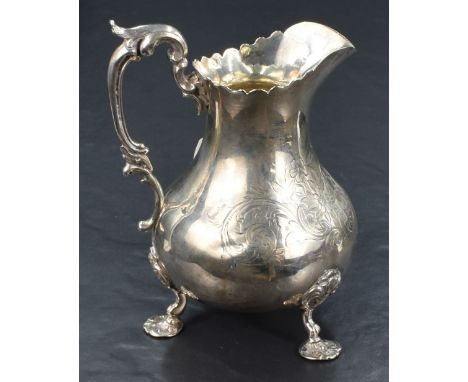 A Victorian silver cream jug of bluster form, having a conforming Chippendale style rim terminating into a pointed spout, opp