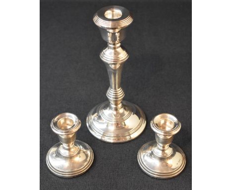 A pair of Elizabeth II silver squat candlesticks, the sconces of circular form raised on weighted circular step moulded feet,