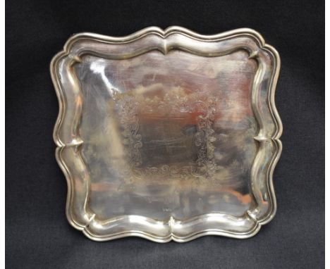 An Edwardian silver tray, of square form with moulded and shaped Chippendale influenced rim enclosing the central foliate eng