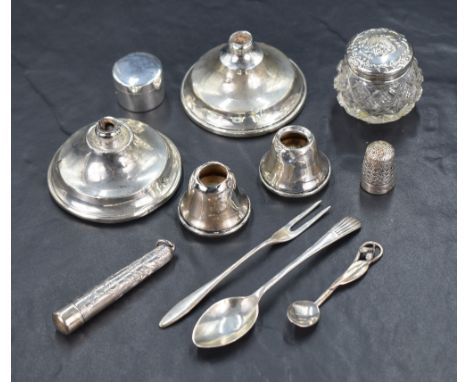 An assortment of silver items, including two weighted candlestick bases and two candlestick sconces, a thimble, a silver moun