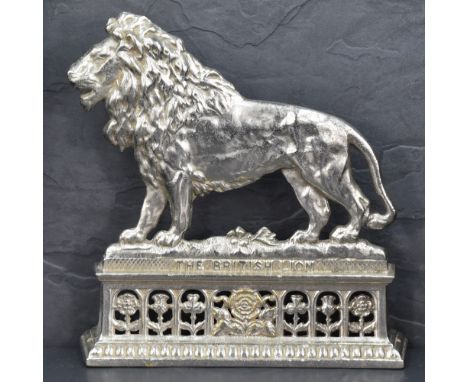 A Victorian silver plated fireside ornament depicting 'the British Lion' situated on a platform below which is a central Engl
