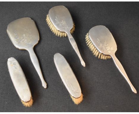 An early Elizabeth II silver mounted vanity set, comprising two hair brushes, two clothes brushes and a mirror, all with engi