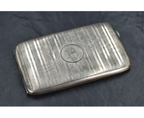 A George V silver cigarette case of rectangular form, having vertical stripes of engine turned decoration with a central circ