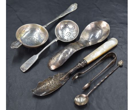 An assortment of silver flatware and cutlery, including a Russian fiddle pattern sugar sifting spoon with decorative floral e