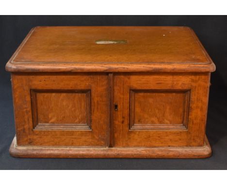 A late 19th / early 20th century oak canteen, having a central rectangular brass plaque and brass handles, containing a part 