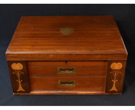 An Art Nouveau mahogany canteen, having a central brass shield inlay, brass handles and decorative wooden inlays to front, co