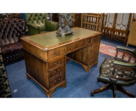 A Leather Topped Twin Pedestal Desk of typical form, three frieze drawers, two banks of three drawers, raised on bracket feet