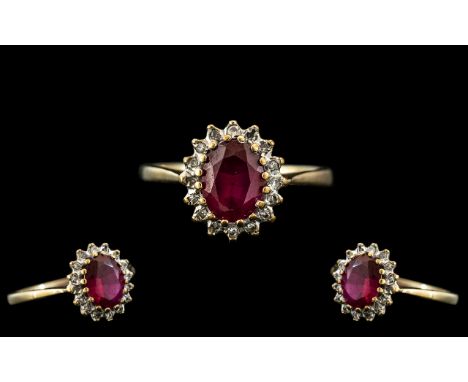 A 9ct Gold Red Stone Dress Ring surrounded by small diamonds,