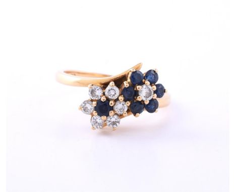 A SAPPHIRE AND DIAMOND DOUBLE FLOWER HEAD CLUSTER RING LONDON 1980 The alternating flower heads set with circular cut sapphir