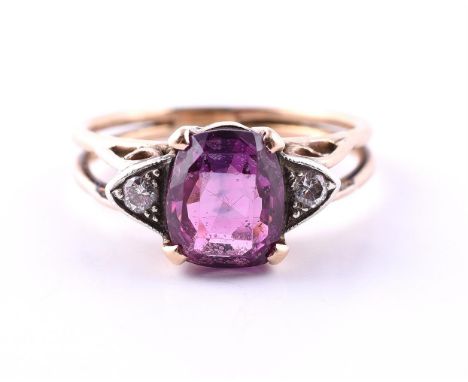 A PINK SAPPHIRE AND DIAMOND THREE STONE RING The oval cut pink sapphire estimated to weigh 2.12 carats, flanked by two brilli