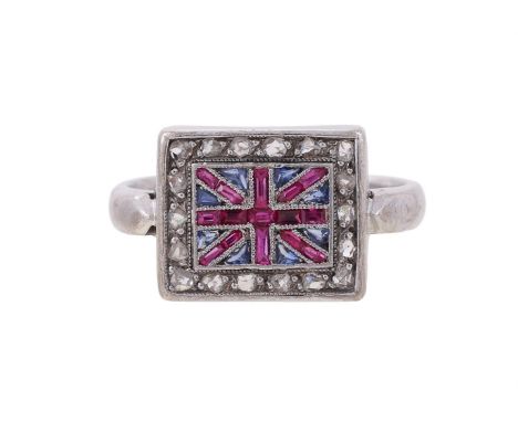A DIAMOND SAPPHIRE AND RUBY UNION JACK DRESS RING  The rectangular panel with channel set calibre cut rubies and triangular c