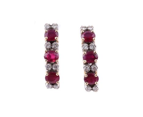 A PAIR OF DIAMOND AND RUBY EARRINGS The trio of oval cut rubies, interspaced with pairs of brilliant cut diamonds, approximat