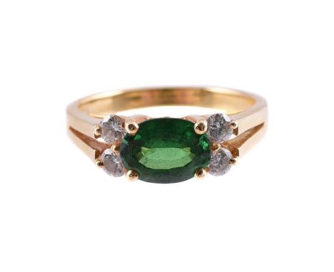  A TSAVORITE GARNET AND DIAMOND FIVE STONE RING  The oval cut tsavorite garnet flanked by two pairs of brilliant cut diamonds