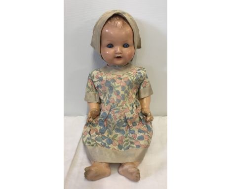 An Armand Marseille composite baby doll with vintage silk dress and bonnet. Marked A.M. Germany 520/23/4k. One finger missing