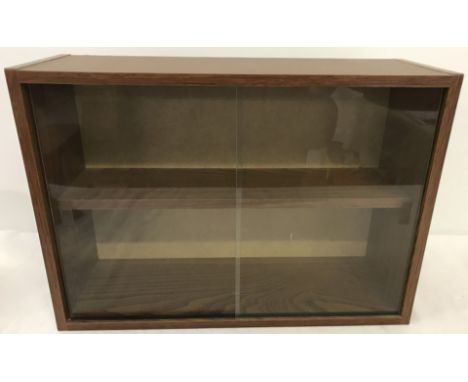 A wood effect wall hanging display cabinet. With interior shelf and 2 sliding glass doors. 32cm tall x 46.5 wide.