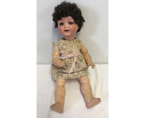 A vintage composite fully jointed doll with teeth and close eye action. Marked Germany to back of head. Shows some signs of r