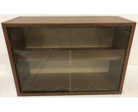 A wood effect wall hanging display cabinet. With internal shelf and 2 front glass sliding doors. 32 5cm tall x 46.5cm wide.