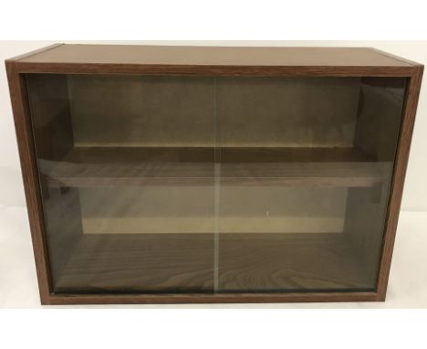 A wood effect wall hanging display cabinet. With interior shelf and 2 sliding glass doors. 32cm tall x 46.5 wide.