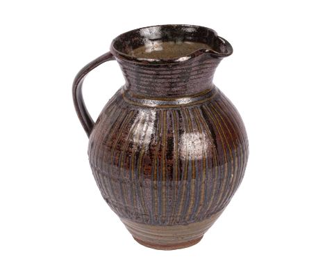 ARR Abuja Pottery a stoneware jug with reflective brown-red linear decoration atop a dark green glaze, impressed P.K mark ben