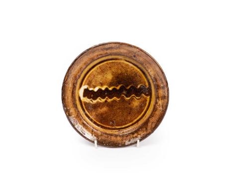 ARR Michael Cardew (1901-1983) a glazed plate with wavy line design to centre, 19cm diameter
