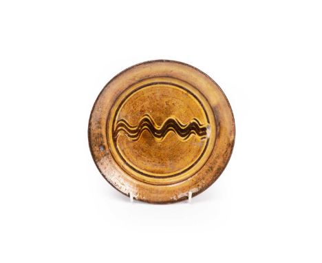 ARR Michael Cardew (1901-1983) a brown and yellow glazed dish, 18.5cm diameter