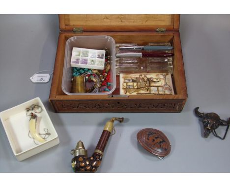 Carved sandalwood box of sarcophagus form, the interior revealing assorted items including: fountain pens, glass pen holders,