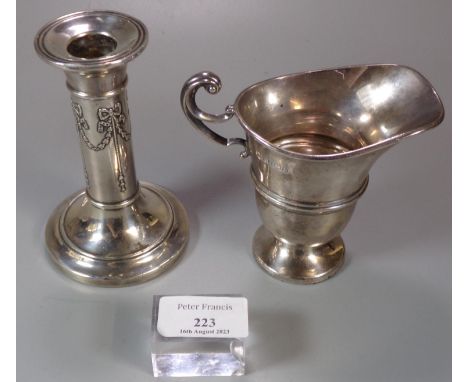 Silver helmet shaped cream jug with Birmingham hallmarks, 4.1 troy oz approx.  Together with a silver single candlestick with