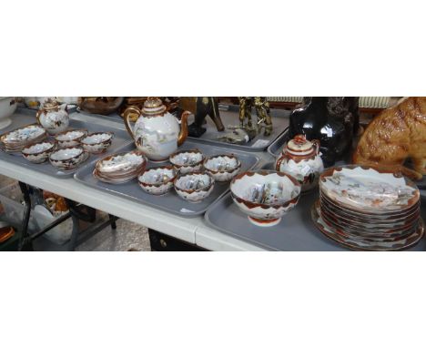 Three trays of Japanese eggshell porcelain items with Geisha girl and pagoda design, to include: coffee pot, lidded water jug