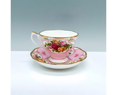 A delicately painted teacup and saucer set adorned with a light pink background and a charming rose motif for the design. Roy