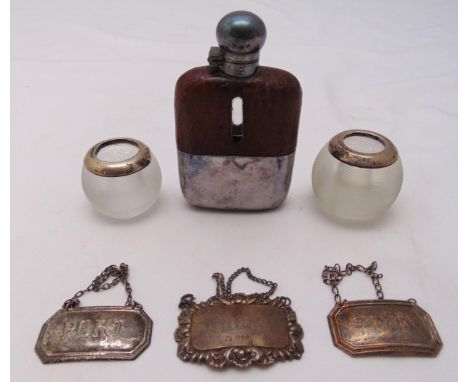 Three hallmarked silver labels, two match holders and a silver plated and leather hip flask (6)