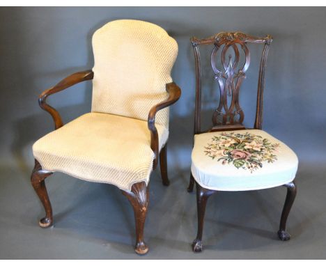 A Queen Anne Style Armchair with an upholstered back and seat with shaped arms raised upon carved cabriole legs with pad feet