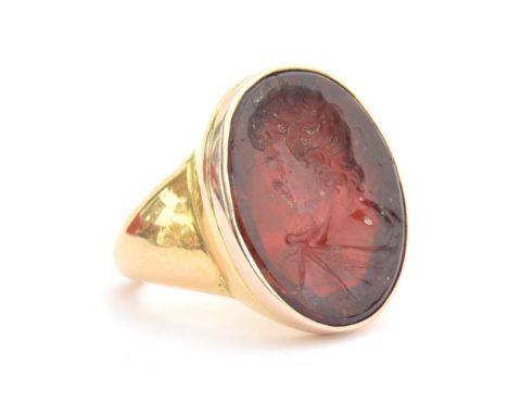 A large and heavy Georgian gold mounted garnet intaglio portrait ring, the gold in two colours, the large possibly earlier ga