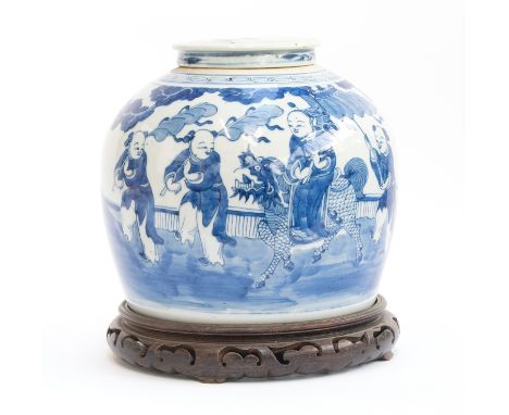 A large Chinese Kangxi style porcelain blue and white ginger jar (cracked), depicting festival scenes, 21.5cm high, on a carv