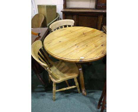 Pine dining table, with circular top, raised on a turned stem and tripod legs, 90cm diameter, two dining chairs with solid di
