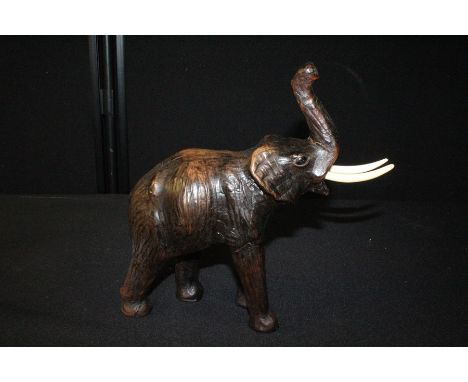 Leather clad elephant, with a raised trunk, 28cm high