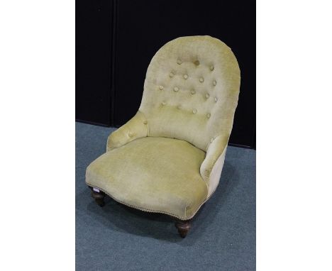 Edwardian nursing chair, upholstered in a gold coloured fabric, with button back nand serpentine front seat, on turned legs