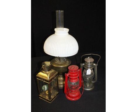 Brass oil lamp with glass chimney and shade together with two smaller oil/storm lamps and a candle lantern, (4)
