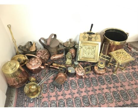 A large collection of brass and copper ware including fireplace tools, decorations, an oil lamp, photo frame, watering cans ,
