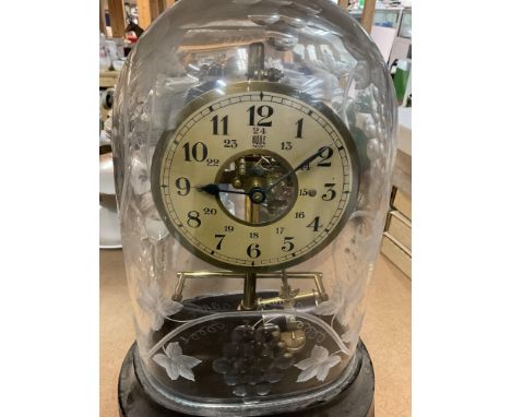 A Bulle electric mantle clock under a glass engraved dome .