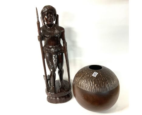 A large African carved wooden figure together with a globe shaped vase.