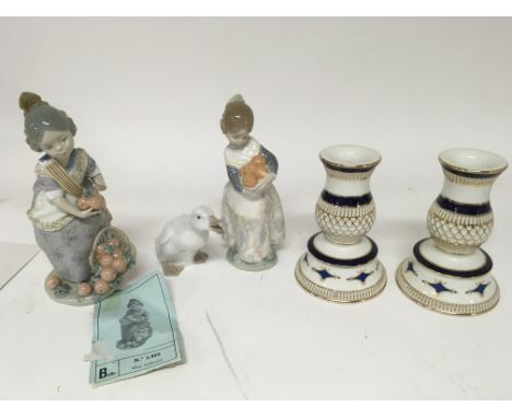 A Lladro figure Miss Valencia with a basket of fruit one other similar Lladro figure and a pair of candle stick and a a Lladr