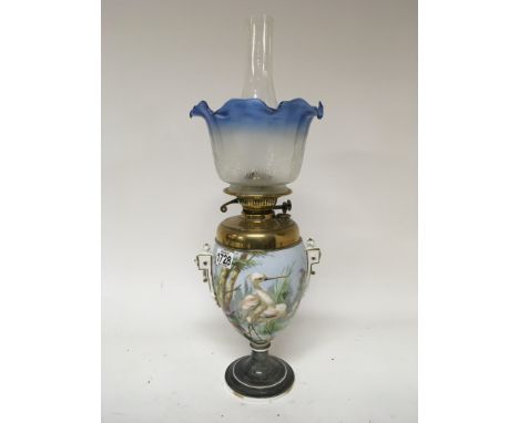 A Victorian porcelain oil lamp the sides decorated with birds with a brass reservoir acid etched blue glass shade and glass c