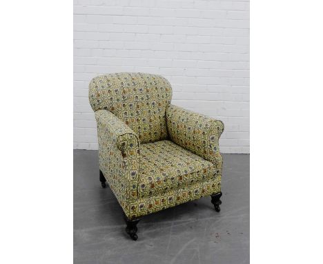 A floral upholstered armchair on mahogany supports and ceramic castors, 80 x 66cm