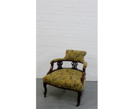 An upholstered armchair on mahogany shaped side supports and cabriole legs terminating in ceramic castors, 75 x 64cm 