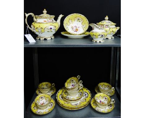 A 19th century Rockingham style yellow glazed tea set with gilt rims and hand painted floral sprays, comprising seven cups, s