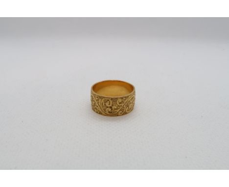 A 22ct yellow gold (hallmarked) band with chased decoration - ring size L - weight approx 6.7 grams 